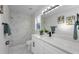 Updated bathroom with marble shower, white cabinets, and modern vanity at 9800 Mendel Dr, New Port Richey, FL 34654