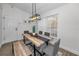 Bright dining room features a rustic wood table, bench seating, and modern light fixture at 9800 Mendel Dr, New Port Richey, FL 34654