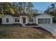 Single-story house with red tile roof, attached garage, and manicured lawn at 9800 Mendel Dr, New Port Richey, FL 34654