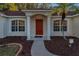 Front entrance with red door, columns, and landscaped walkway at 9800 Mendel Dr, New Port Richey, FL 34654