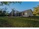 Back exterior view of house with pool and screened enclosure at 9800 Mendel Dr, New Port Richey, FL 34654