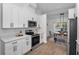 Modern kitchen with white cabinets and stainless steel appliances at 9800 Mendel Dr, New Port Richey, FL 34654