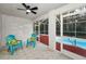 Bright pool enclosure with two teal chairs and view of refreshing pool at 9800 Mendel Dr, New Port Richey, FL 34654