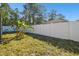 Grass backyard with a white fence and banana trees at 10703 Aldo Moro Dr, Wimauma, FL 33598