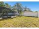 Fenced backyard with grassy area and tropical plants at 10703 Aldo Moro Dr, Wimauma, FL 33598