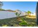 Landscaped backyard featuring banana trees and a fence at 10703 Aldo Moro Dr, Wimauma, FL 33598