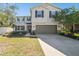 Two-story house with a neutral color scheme, two-car garage, and landscaped front yard at 10703 Aldo Moro Dr, Wimauma, FL 33598