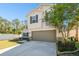 Two-story house with a neutral color scheme, two-car garage, and landscaped front yard at 10703 Aldo Moro Dr, Wimauma, FL 33598