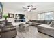 Bright living room with hardwood floors, sectional sofa, and mounted TV at 10703 Aldo Moro Dr, Wimauma, FL 33598