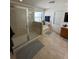 Modern bathroom featuring a glass-enclosed shower, soaking tub, and tiled floors at 1449 Kaffir Lily Ct, Trinity, FL 34655