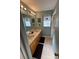 Bathroom with double sinks, light brown cabinets, and a bathtub at 1449 Kaffir Lily Ct, Trinity, FL 34655