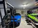 Two-car garage with storage space, a blue sports car, and a personal watercraft at 1449 Kaffir Lily Ct, Trinity, FL 34655