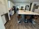 Spacious kitchen with island, bar seating, white cabinetry, and wood-look floors at 1449 Kaffir Lily Ct, Trinity, FL 34655