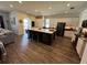 Open-concept kitchen and living area with island seating and wood-look floors at 1449 Kaffir Lily Ct, Trinity, FL 34655