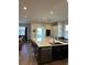 Modern kitchen with large island, dark cabinets, and stainless steel appliances at 1449 Kaffir Lily Ct, Trinity, FL 34655