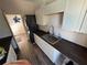 Bright laundry room with dark countertops and a stacked washer/dryer at 1449 Kaffir Lily Ct, Trinity, FL 34655
