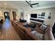 Living room with brown sectional sofa, entertainment center, and wood floors at 1449 Kaffir Lily Ct, Trinity, FL 34655