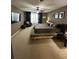 Spacious main bedroom with a large bed, carpeted floors, ceiling fan, and sitting area at 1449 Kaffir Lily Ct, Trinity, FL 34655