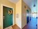 Inviting condo hallway with textured walls, dark doors, and a decorative wreath on the unit's front door at 2724 Via Murano # 633, Clearwater, FL 33764