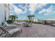 Outdoor patio with lounge chairs, tables, and grills overlooking the ocean at 4950 Gulf Blvd # 206, St Pete Beach, FL 33706