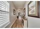 Long hallway with hardwood floors and white shutters at 5205 Covesound Way, Apollo Beach, FL 33572