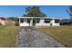 Ranch style home with gray exterior, driveway, and landscaped lawn at 10273 109Th Ave, Largo, FL 33773