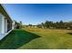 Large backyard with lush grass and distant water view at 11443 Sinatra Ct, New Port Richey, FL 34654