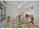 Bright dining room with glass-top table and seating for eight, offering views to the kitchen at 119 8Th E St, Tierra Verde, FL 33715