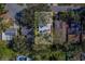 Aerial view highlighting a single-Gathering home nestled among lush greenery at 1638 St Catherine W Dr, Dunedin, FL 34698