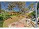 Large backyard with stone patio, multiple seating areas, and lush landscaping at 1638 St Catherine W Dr, Dunedin, FL 34698