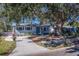 Cute ranch home with a tree-shaded front yard, driveway, and walkway at 1638 St Catherine W Dr, Dunedin, FL 34698
