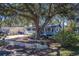 House exterior with a large oak tree and landscaping at 1638 St Catherine W Dr, Dunedin, FL 34698