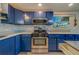 Updated kitchen featuring blue cabinets, stainless steel appliances and an island at 1638 St Catherine W Dr, Dunedin, FL 34698