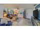 Living room with brown couch, large TV, and blue accents at 1638 St Catherine W Dr, Dunedin, FL 34698