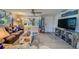Cozy living room featuring a brown leather couch, large TV, and wood-look floors at 1638 St Catherine W Dr, Dunedin, FL 34698