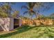Beige storage shed with black doors in a backyard setting at 1638 St Catherine W Dr, Dunedin, FL 34698