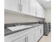 Laundry room with white cabinets, dark gray countertop, sink, and washer/dryer at 17907 Woodland View Dr, Lutz, FL 33548