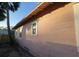 Side view of a light pink house with windows and simple landscaping at 1816 45Th S St, St Petersburg, FL 33711