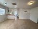 Bright living room featuring terrazzo floors flowing into an adjacent kitchen with breakfast bar at 3211 S Ferdinand Ave, Tampa, FL 33629
