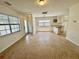 Bright living area with neutral walls, large windows, and partial kitchen view, perfect for comfortable living at 3211 S Ferdinand Ave, Tampa, FL 33629