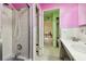 Pink bathroom with a shower, vanity, and view into another room at 545 Lillian Dr, Madeira Beach, FL 33708