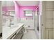 Pink bathroom with white tiled walls, tub, and vanity needing some updates at 545 Lillian Dr, Madeira Beach, FL 33708