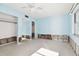 A damaged bedroom with light blue walls, exposed studs, and a ceiling fan at 545 Lillian Dr, Madeira Beach, FL 33708