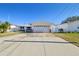 Front view of a single-story house with a garage and a brick facade at 545 Lillian Dr, Madeira Beach, FL 33708