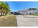 Exterior view of a single-story house with a palm tree in front and a driveway at 545 Lillian Dr, Madeira Beach, FL 33708