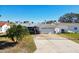 Single-story home with attached garage, palm trees and a large yard at 545 Lillian Dr, Madeira Beach, FL 33708
