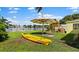 Backyard with kayak, playset, and patio umbrella at 8800 Sunlit Cove Ne Dr, St Petersburg, FL 33702