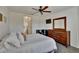 Serene bedroom with a view into the bathroom, ceiling fan, and dresser at 9776 Carlsdale Dr, Riverview, FL 33578