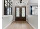 Bright and airy entryway with hardwood floors and an ornate mirror at 9901 Tree Tops Lake Rd, Tampa, FL 33626