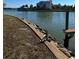 Picturesque waterfront view showing the canal edge with seawall and wooden dock and calm waters at 1285 79Th St S, St Petersburg, FL 33707